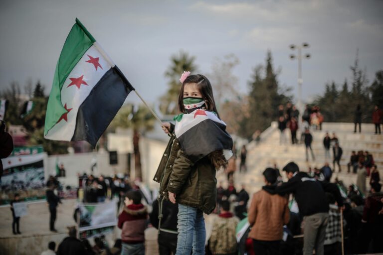 Photo by Ahmed akacha: https://www.pexels.com/photo/portrait-of-girl-holding-syria-flag-10629491/